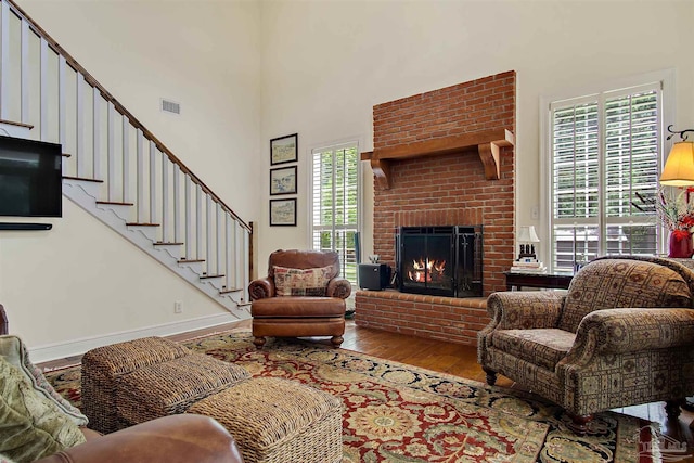 607 Goodwill Cir, Silas, AL 36919 - living area with hardwood / wood-style flooring, healthy amount of natural light, a towering ceiling, stairway, and a fireplace
