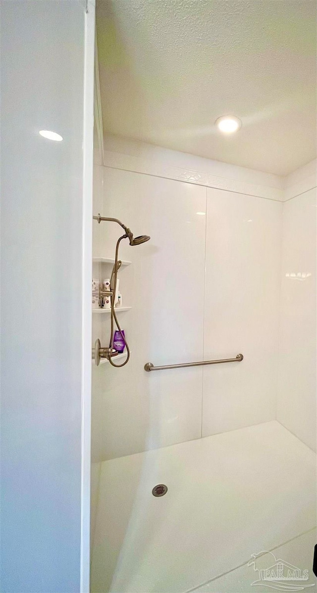 bathroom featuring a shower and a textured ceiling