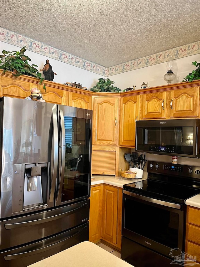 kitchen with a textured ceiling and stainless steel appliances