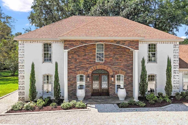 457 Boone Ln, Fairhope, AL 36532 - french country style house with stone siding, roof with shingles, and french doors