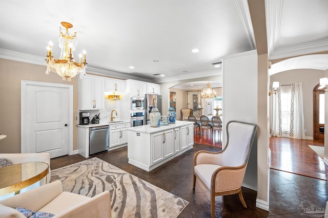 457 Boone Ln, Fairhope, AL 36532 - kitchen featuring a chandelier, arched walkways, stainless steel appliances, a sink, and a center island