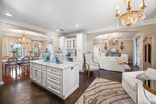 kitchen with dark tile patterned flooring, ornamental molding, a center island, pendant lighting, and white cabinets