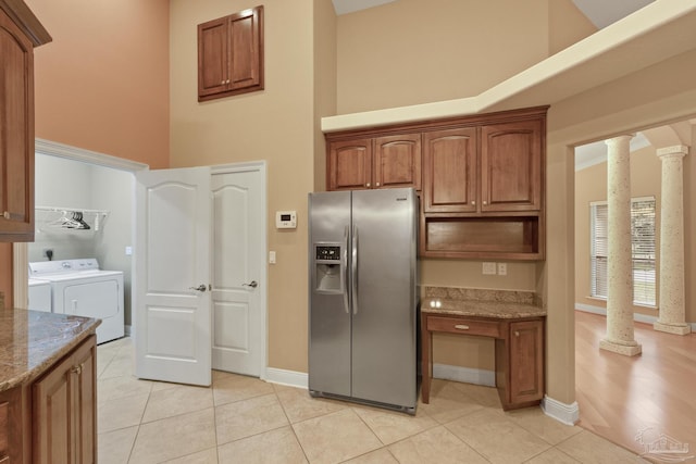 kitchen with stainless steel refrigerator with ice dispenser, ornate columns, stone counters, and light tile patterned floors