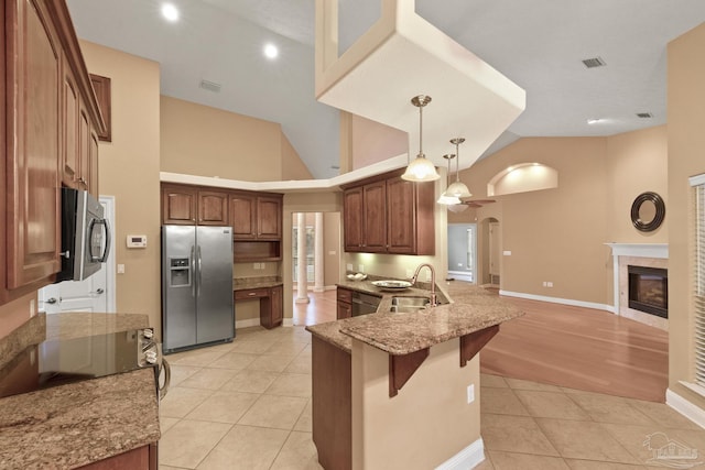 kitchen featuring decorative light fixtures, sink, light tile patterned flooring, a kitchen breakfast bar, and stainless steel appliances