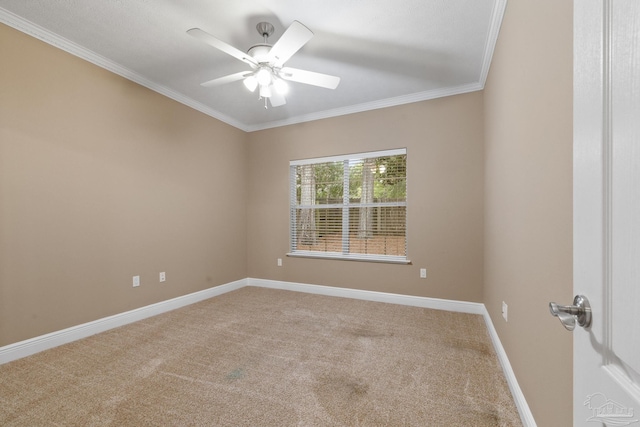 carpeted spare room featuring ceiling fan and crown molding