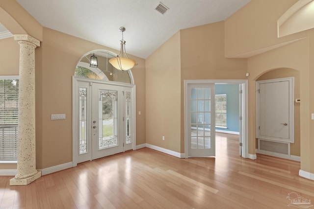 foyer featuring light hardwood / wood-style floors and ornate columns