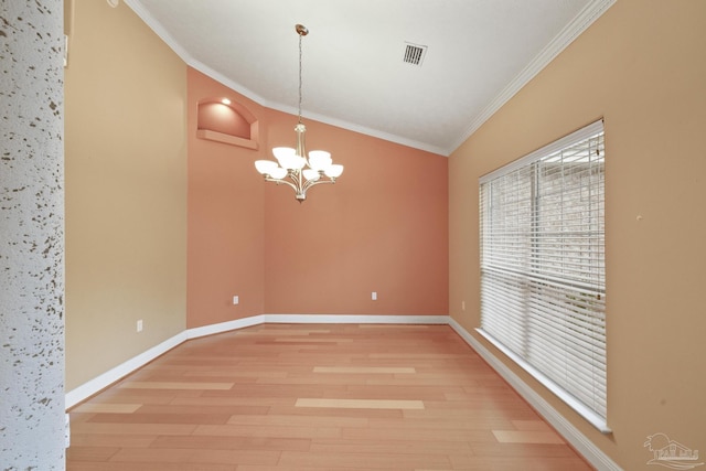 empty room featuring lofted ceiling, an inviting chandelier, ornamental molding, and hardwood / wood-style flooring