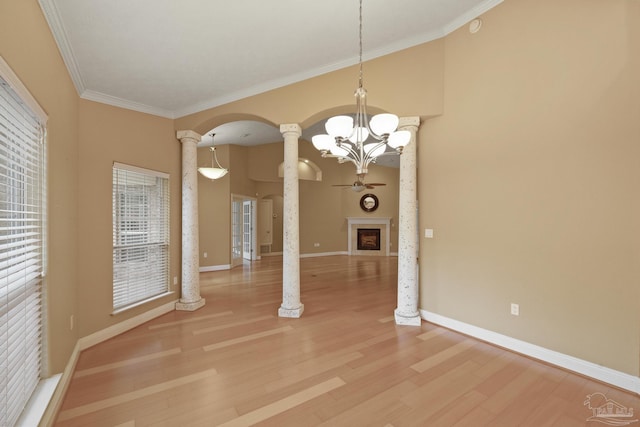 unfurnished dining area featuring decorative columns, hardwood / wood-style floors, ornamental molding, and a chandelier