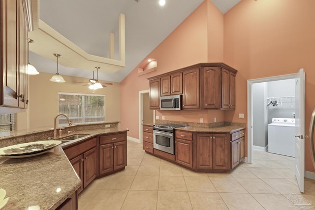 kitchen with ceiling fan, stainless steel appliances, light tile patterned flooring, washer / clothes dryer, and sink