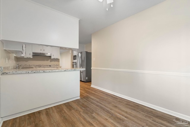 3481 Summit Blvd, Pensacola, FL 32503 - kitchen with freestanding refrigerator, under cabinet range hood, dark wood-type flooring, baseboards, and a sink