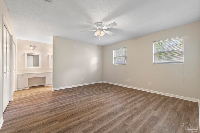 3481 Summit Blvd, Pensacola, FL 32503 - unfurnished bedroom with wood finished floors, baseboards, connected bathroom, and a textured ceiling
