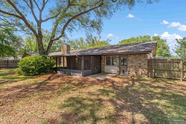 3481 Summit Blvd, Pensacola, FL 32503 - rear view of property with a chimney, a sunroom, and brick siding