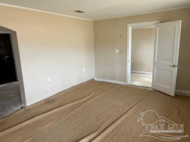 carpeted empty room featuring baseboards and ornamental molding