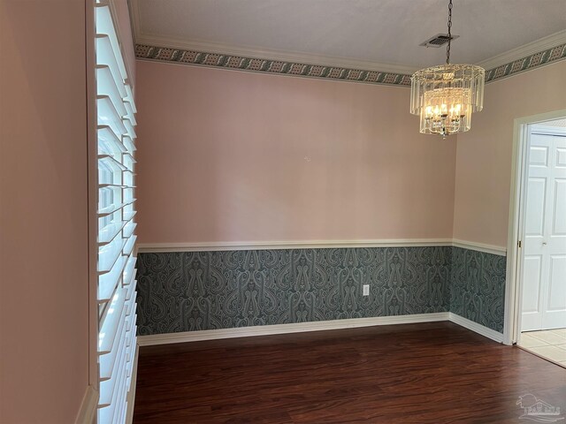 spare room with visible vents, dark wood finished floors, baseboards, a chandelier, and wallpapered walls