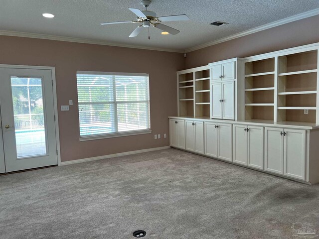 unfurnished living room with a ceiling fan, a wealth of natural light, and light carpet