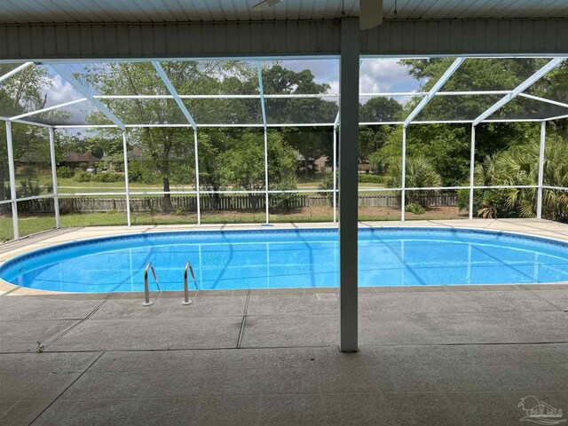 outdoor pool with fence, a lanai, and a patio