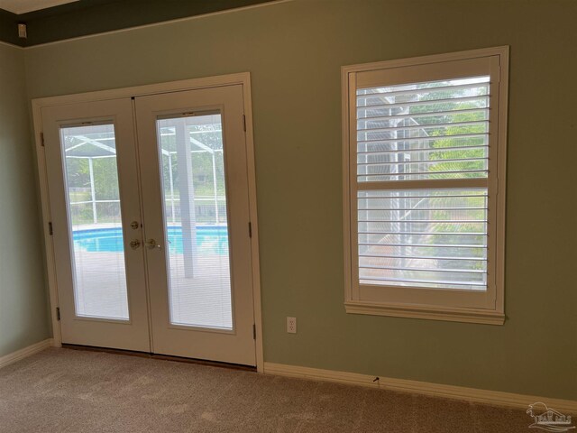 doorway featuring french doors, baseboards, and light colored carpet