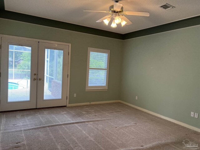 spare room featuring french doors, carpet, baseboards, and visible vents