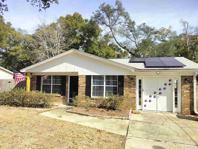 ranch-style home featuring solar panels