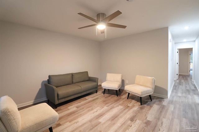 living room featuring ceiling fan and light hardwood / wood-style flooring