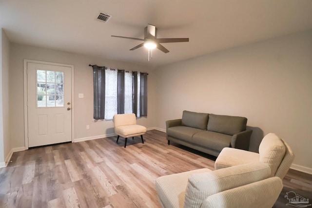 living room with wood-type flooring and ceiling fan