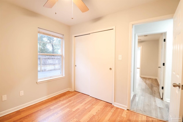 unfurnished bedroom with light hardwood / wood-style floors, a closet, and ceiling fan