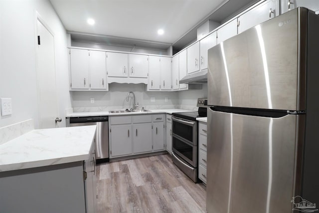 kitchen with gray cabinetry, sink, light hardwood / wood-style floors, and appliances with stainless steel finishes