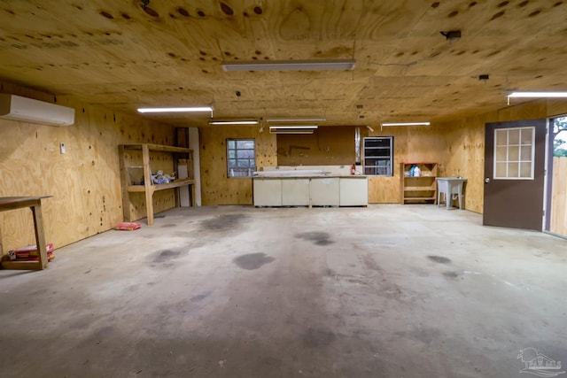 garage with sink, wooden walls, a wall unit AC, and a workshop area