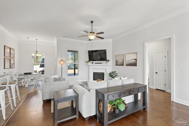 living room featuring dark hardwood / wood-style flooring, ceiling fan with notable chandelier, and ornamental molding