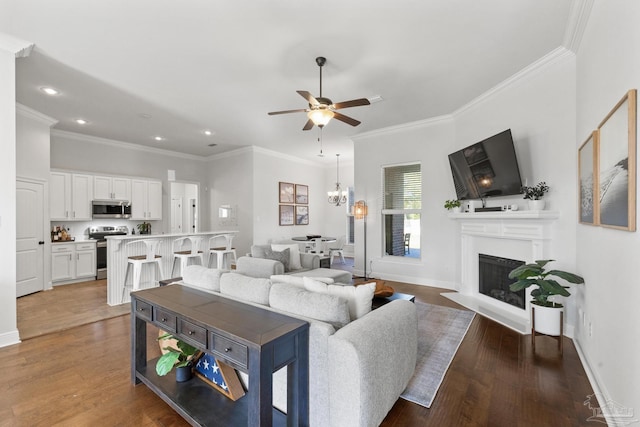 living room with ceiling fan, dark hardwood / wood-style flooring, and crown molding