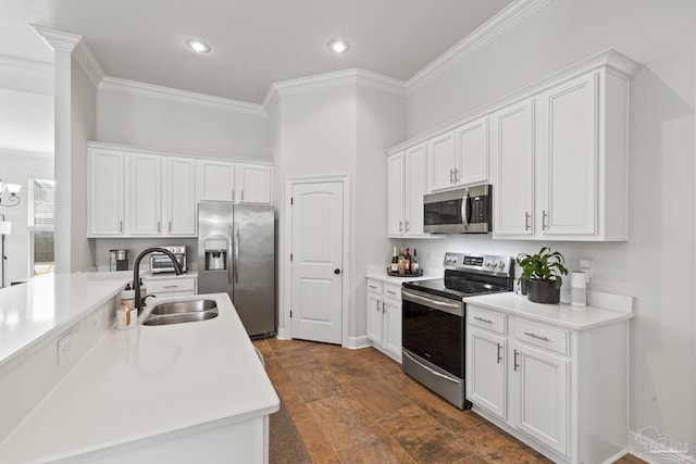 kitchen featuring white cabinets, stainless steel appliances, crown molding, and sink