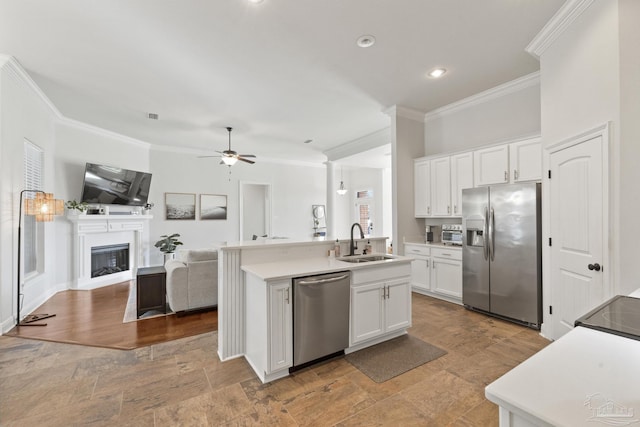 kitchen featuring ceiling fan, sink, stainless steel appliances, an island with sink, and white cabinets