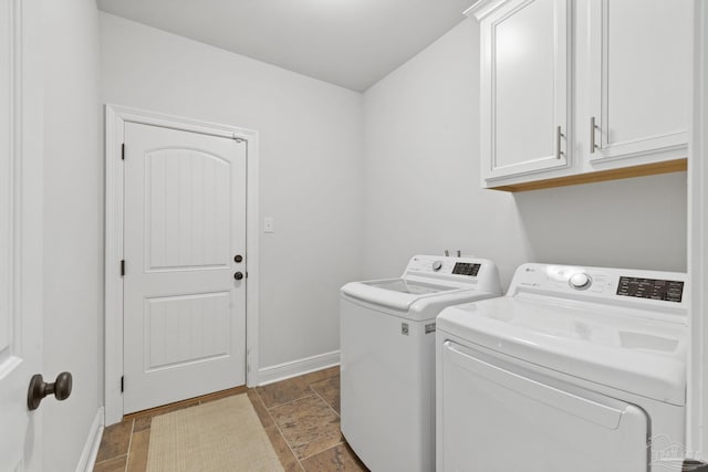 clothes washing area with cabinets and washing machine and dryer