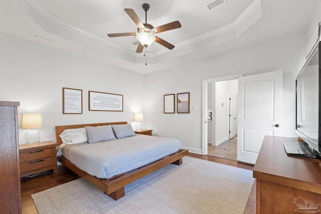 bedroom with ceiling fan, a raised ceiling, and crown molding