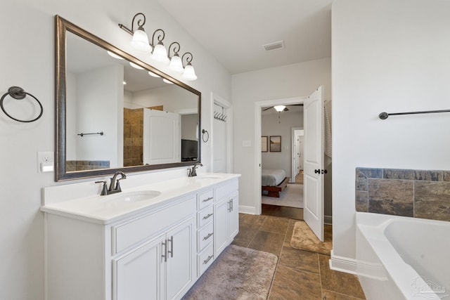 bathroom with a washtub and vanity