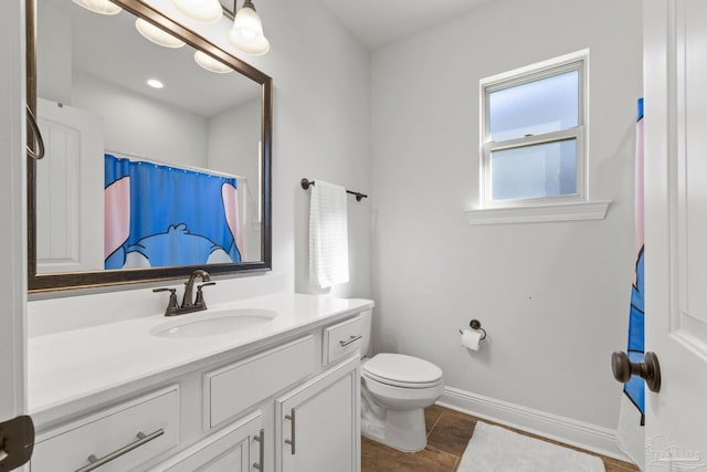 bathroom featuring vanity, curtained shower, and toilet