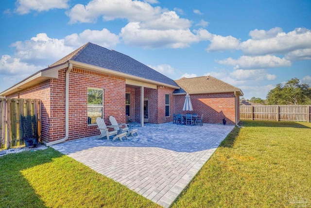 rear view of house featuring a lawn and a patio area