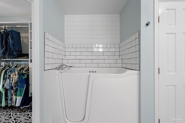 1933 Eagle Ln, Navarre, FL 32566 - bathroom with a garden tub, a spacious closet, and decorative backsplash