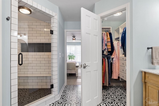 1933 Eagle Ln, Navarre, FL 32566 - ensuite bathroom featuring vanity, a stall shower, a walk in closet, and a ceiling fan
