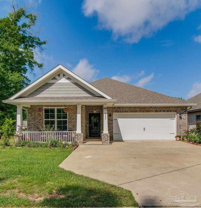 view of front facade featuring brick siding, a front lawn, driveway, and an attached garage