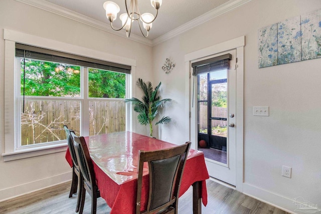 dining room featuring baseboards, ornamental molding, a notable chandelier, and wood finished floors