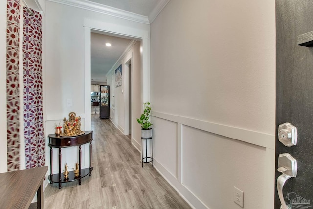 hallway featuring ornamental molding and light wood-type flooring