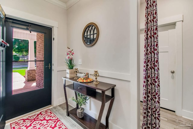 entryway featuring crown molding and light wood finished floors