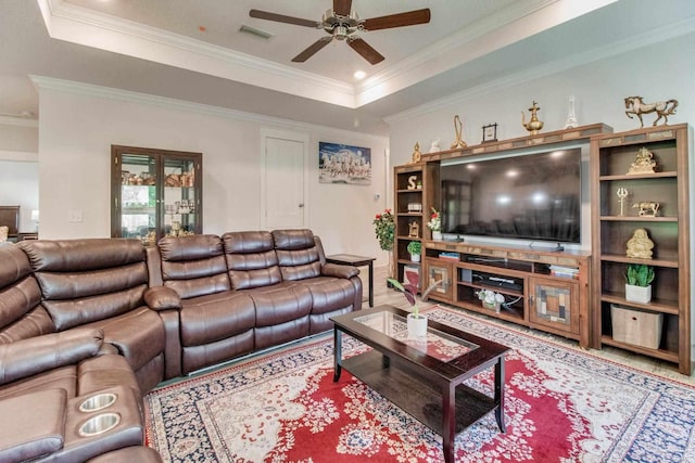 living room featuring a raised ceiling, visible vents, a ceiling fan, and ornamental molding