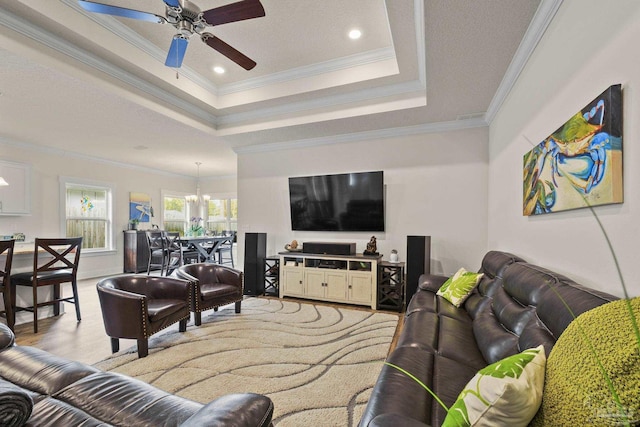 living room with crown molding, ceiling fan, a tray ceiling, and light hardwood / wood-style flooring