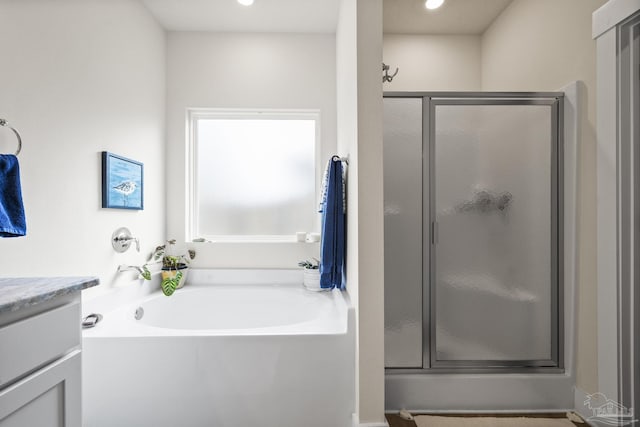 bathroom with vanity and shower with separate bathtub