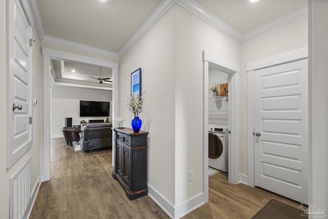 hall with crown molding, dark hardwood / wood-style flooring, and washer / dryer