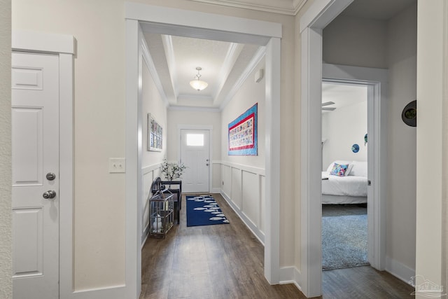 interior space featuring dark hardwood / wood-style flooring, crown molding, and a raised ceiling