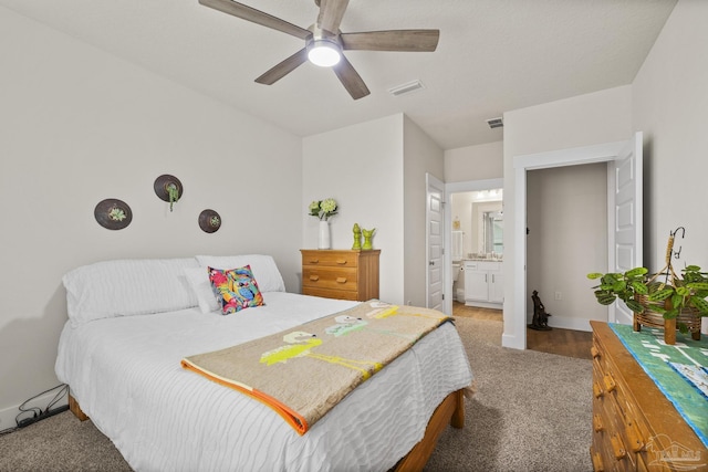 carpeted bedroom featuring ceiling fan and ensuite bath