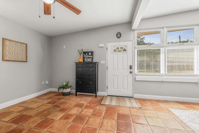 entryway featuring vaulted ceiling, light tile patterned floors, and ceiling fan